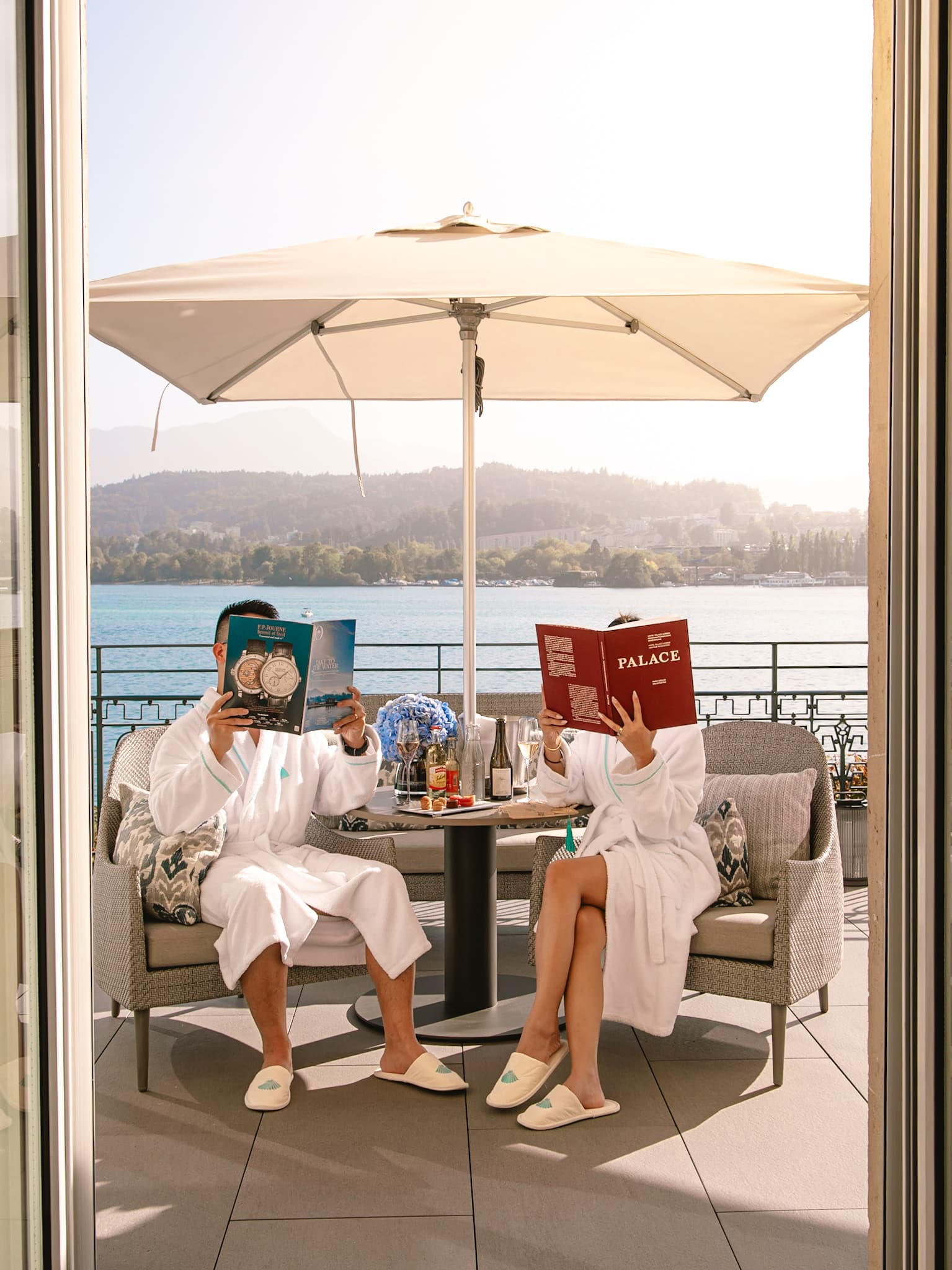 Couple in robes having breakfast on a balcony overlooking Lake Lucerne