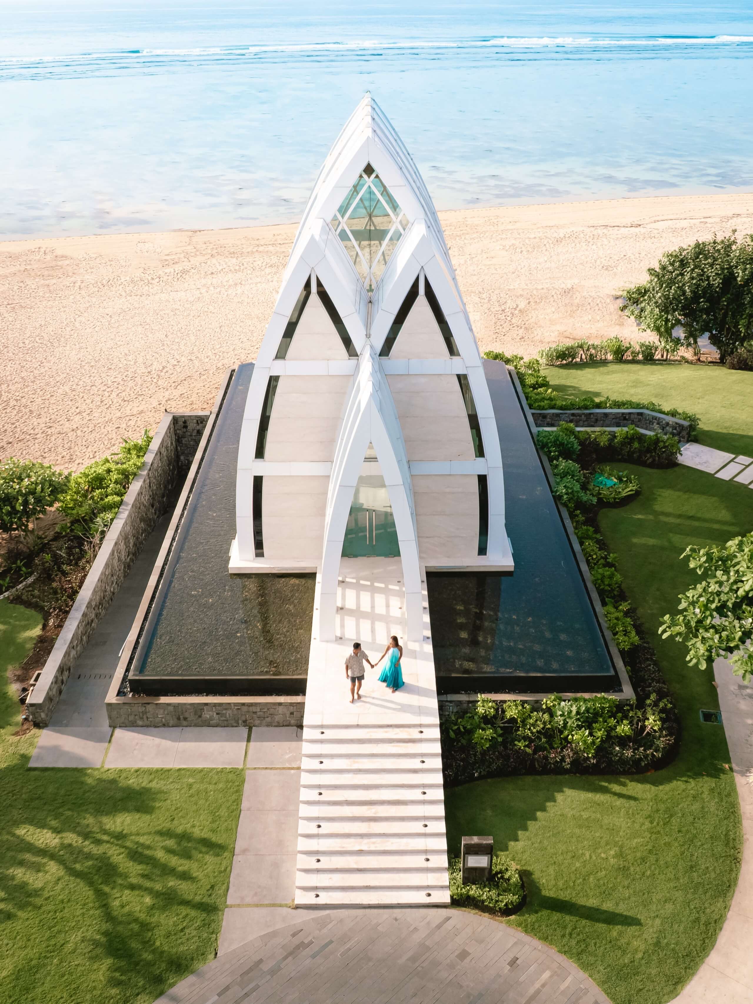Aerial view of the oceanfront wedding chapel at The Ritz-Carlton Bali overlooking the beach and turquoise water.