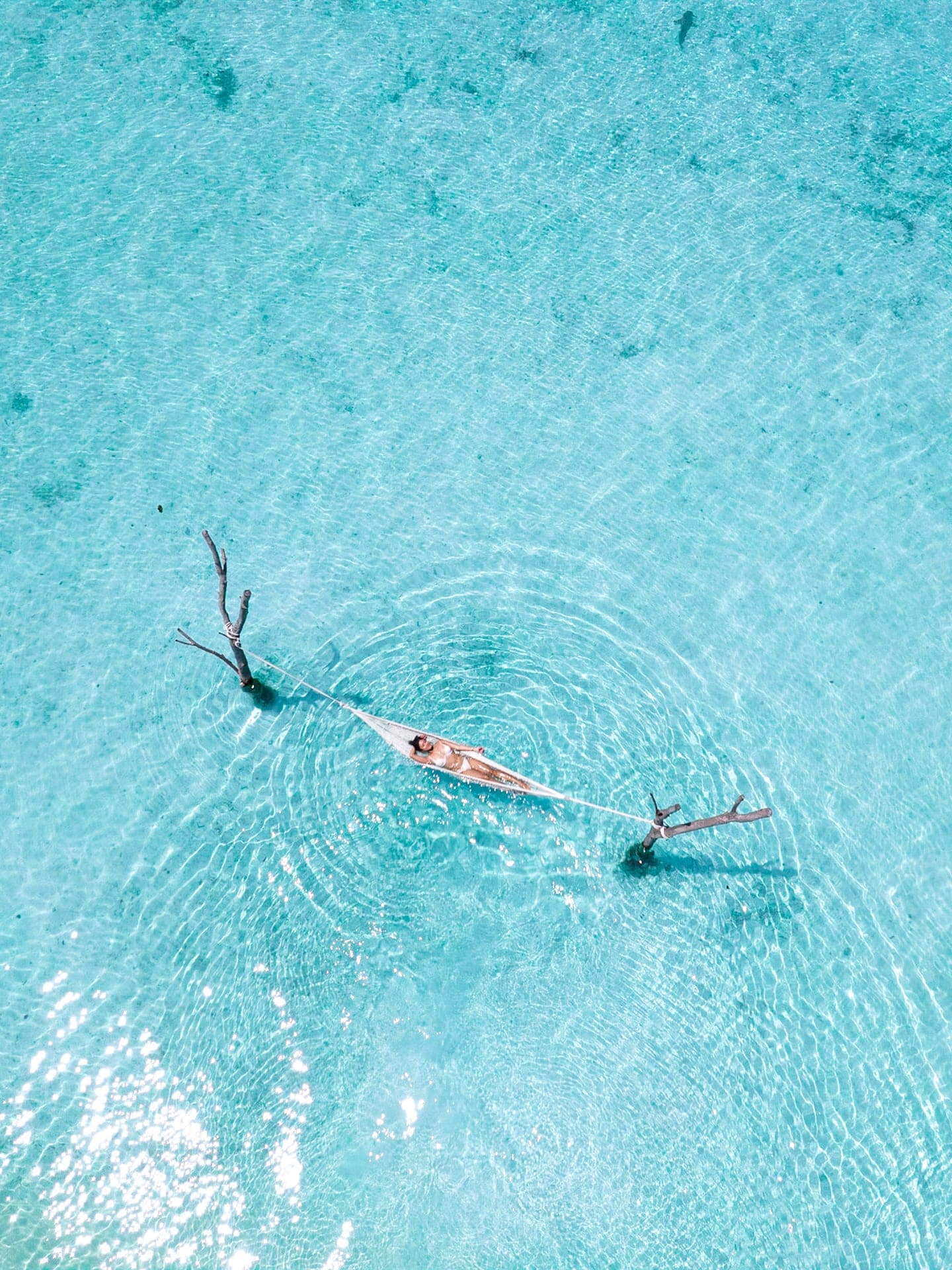 Aerial view of swimmers in a turquoise Maldives lagoon